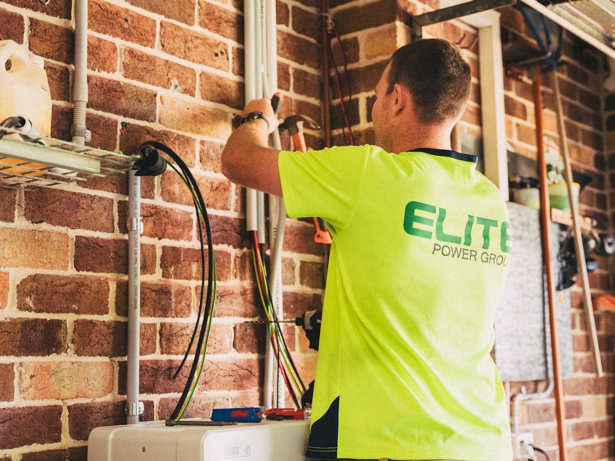 Duvar tipi enerji ekipmanı üzerinde bakım çalışması yapan teknisyen